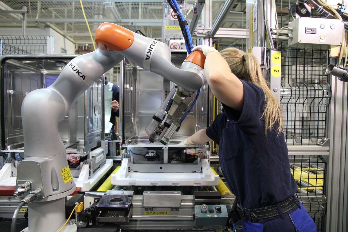 robots KUKA collaborating with workers 